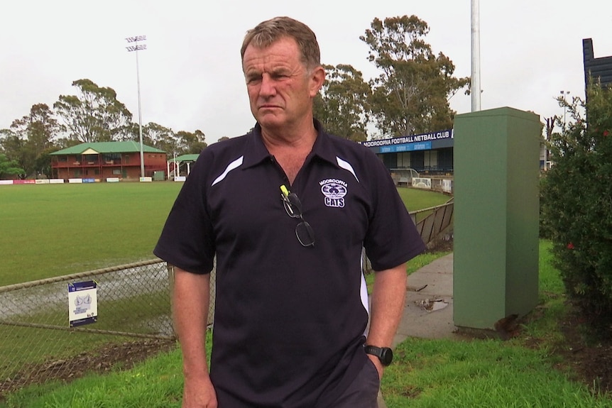 a man standing in front of a football oval