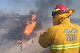 Firefighter watches blaze after gas explosion in California