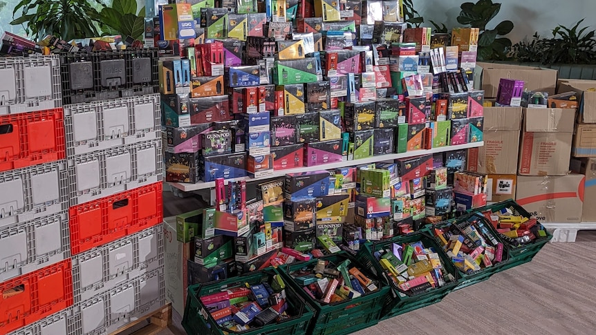 Thousands of vapes stacked on top of each other and inside boxes. 