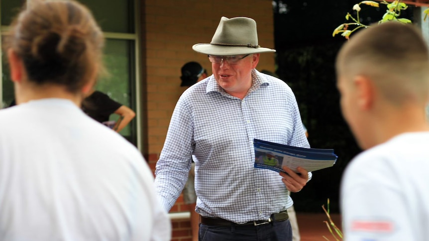 A man handing out how to vote cards