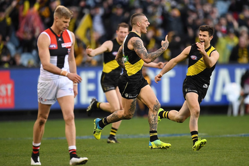 Tigers' Dustin Martin (C) reacts to his goal as he runs past St Kilda's Nick Riewoldt at the MCG.