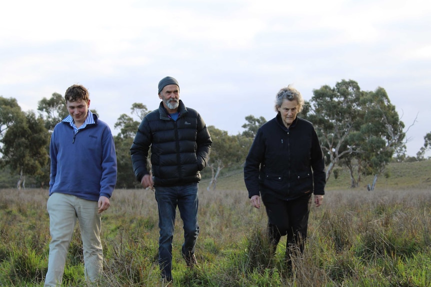 Daniel Lutz, Greg Ludvigsen and Dr Temple Grandin in field.