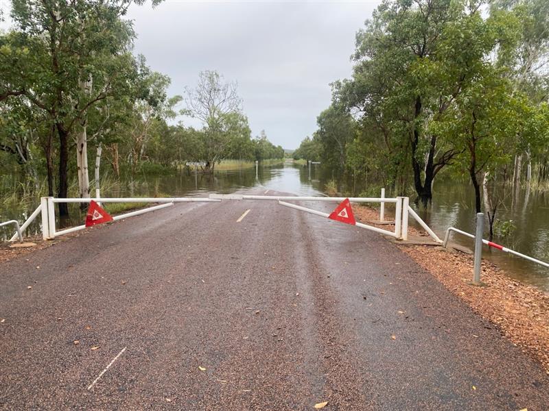 Agua en la calle con una gran puerta y triángulos rojos delante