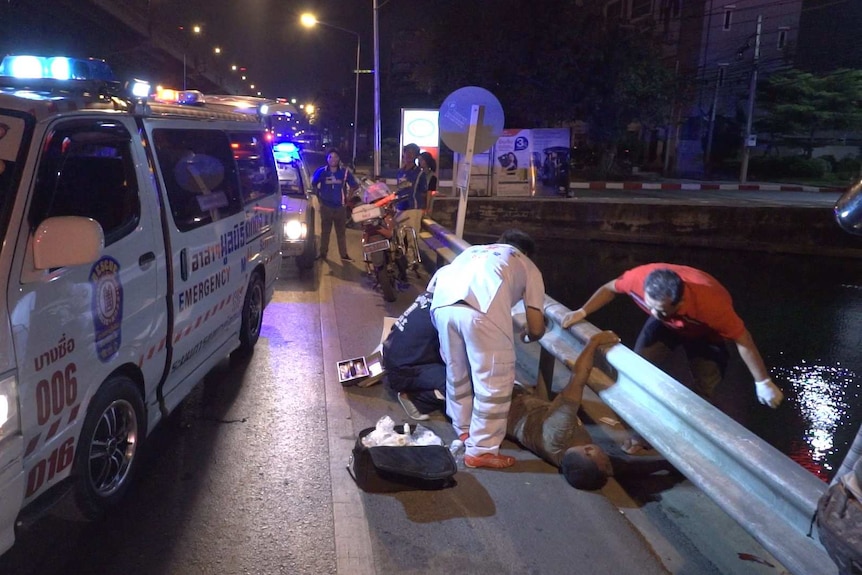 Road crash victim being helped by paramedics in Bangkok