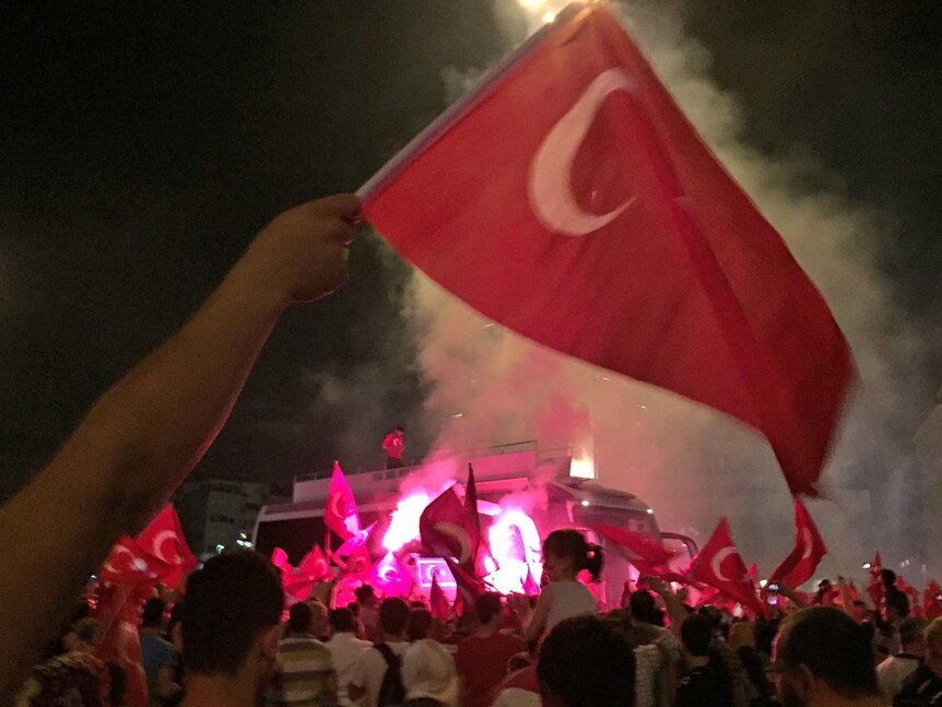People wave Turkish flags on the streets of Istanbul on after a failed coup attempt.