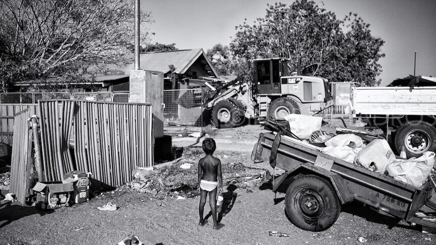 A small boy watches a house being demolished at the Kennedy Hill Aboriginal community in Broome.