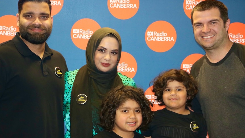 Two young boys, Noah (4) and Yusuf (8), smiling with their parents and presenter Jono Gul