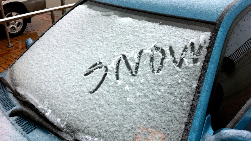 The word 'snow' is written on a car windscreen after Mt Buller received a sprinkling of summer snow.