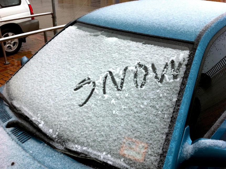 The word 'snow' is written on a car windscreen after Mt Buller received a sprinkling of summer snow.