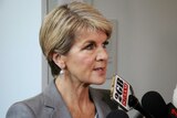 Foreign Minister Julie Bishop talks into a radio journalists microphone at a doorstop.