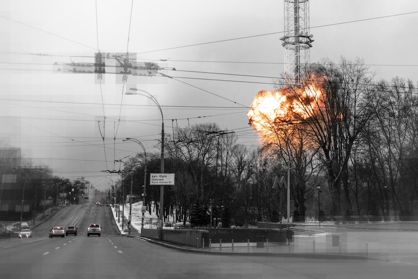 A ball of fire explodes from a metal tower structure as cars pass by. The image has been edited so only the flame is in colour.