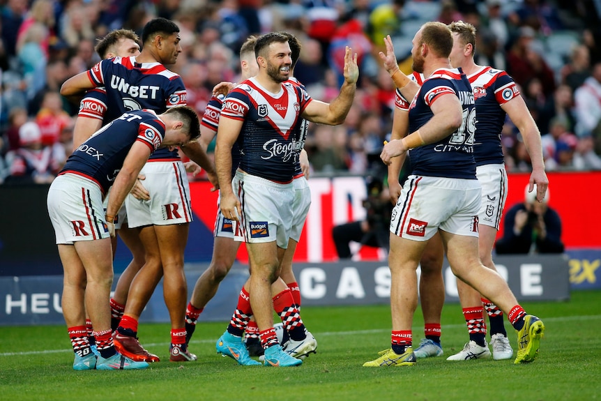 A group of Sydney Roosters NRL players celebrate a try.