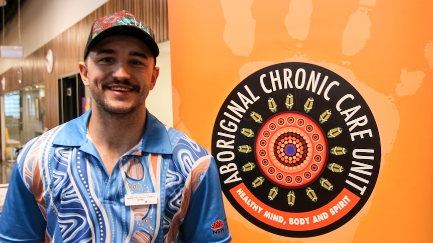 A man wearing a brightly-coloured shirt smiles at the camera