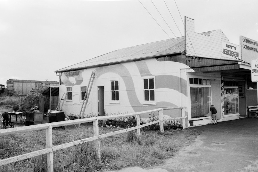 a black and white photo of an old store with distinctive swirl panting down the side