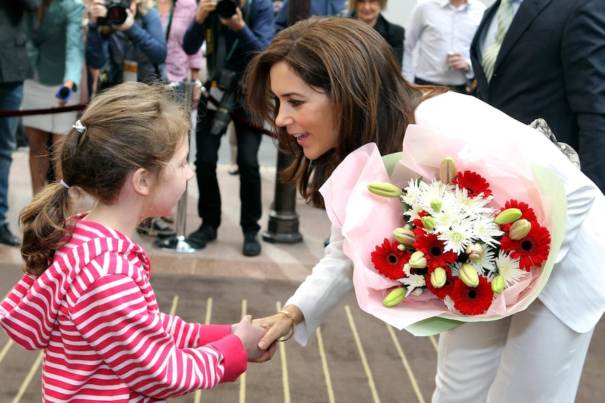 Princess Mary receives flowers from Catherine Babie during her visit to Melbourne.
