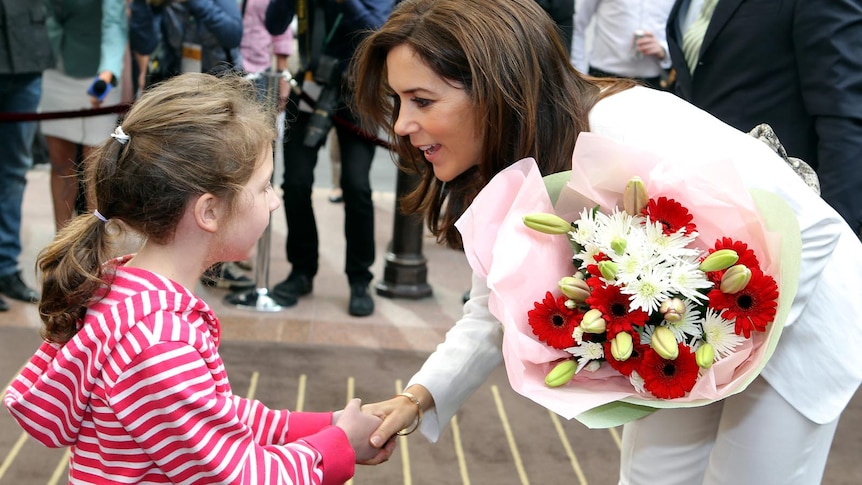 Princess Mary receives flowers from Catherine Babie during her visit to Melbourne.