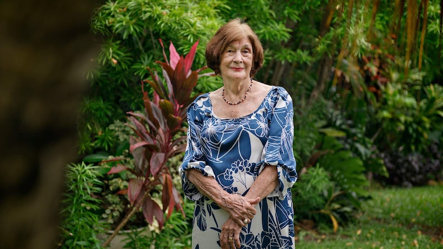 Bombing of Darwin survivor Wendy James stands in a dress in her backyard in Darwin.