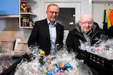 Anthony Albanese and Father Bob Maguire looking at baskets of Easter eggs