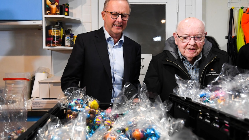 Anthony Albanese and Father Bob Maguire looking at baskets of Easter eggs