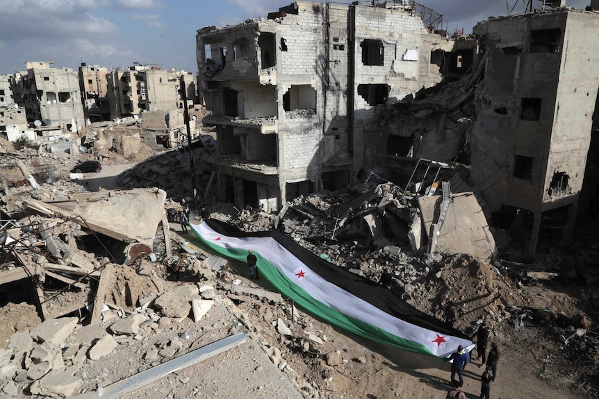 Flag laid on the ground among a scene of rubble