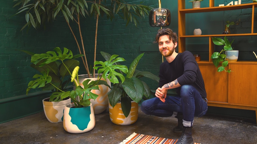 Plant stylist Ryan Klewer crouches beside various pots of plants, and shares tips on how to decorate home with indoor plants.