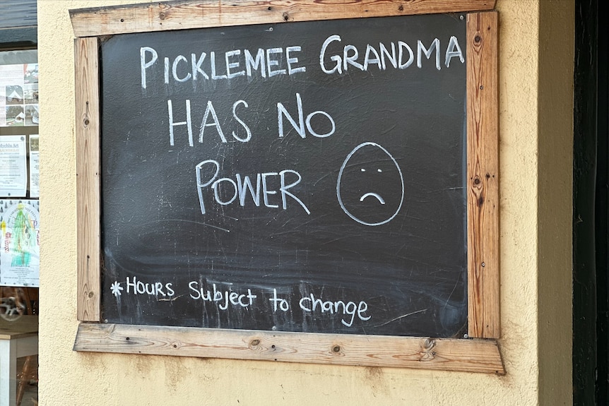 A blackboard signing saying the business has no power alongside a sad face