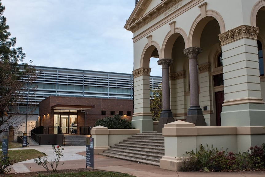 A modern building sits beside the grand traditional old Dubbo court