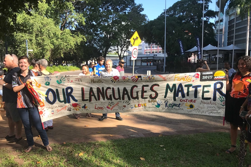 Group holding a hand painted sign that reads 'Our Languages Matter' as part of NAIDOC week