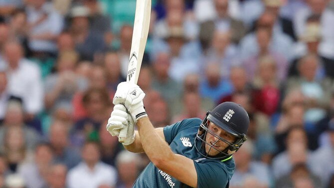 English cricket player David Willey swinging high with his cricket bat to hit a ball