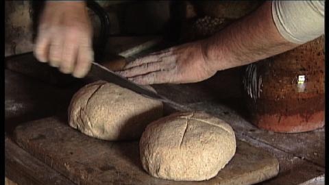 Hands cut two pieces of bread dough with knife