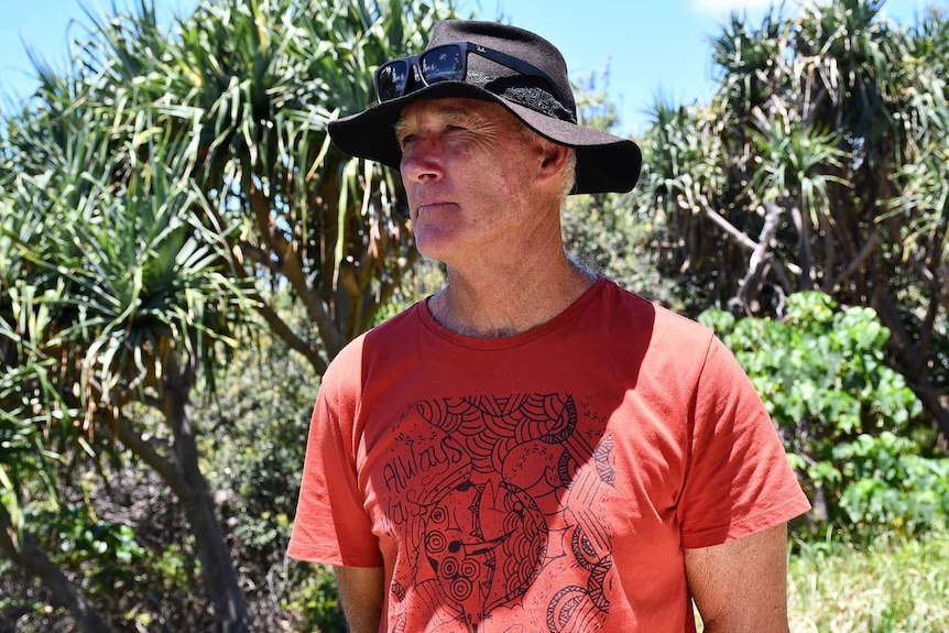 John Truman stands in sun wearing a hat at Point Lookout on North Stradbroke Island.