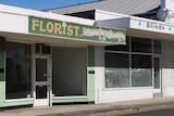 Two empty shop fronts next to each other, one a florist, the other a blinds store.