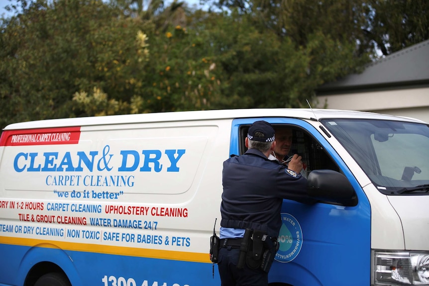 Police speak with a carpet cleaner who arrived at the house.