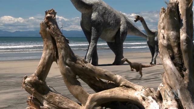 Computer graphic image of dinosaurs walking on a beach