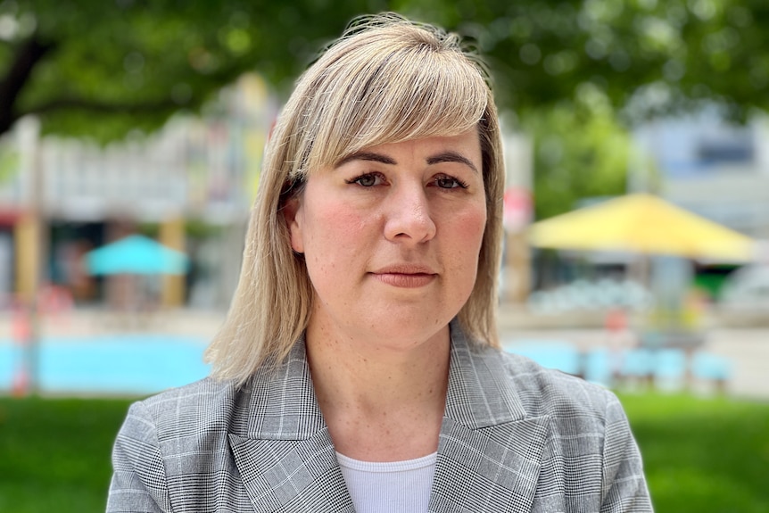 A woman with blonde hair looks concerned.