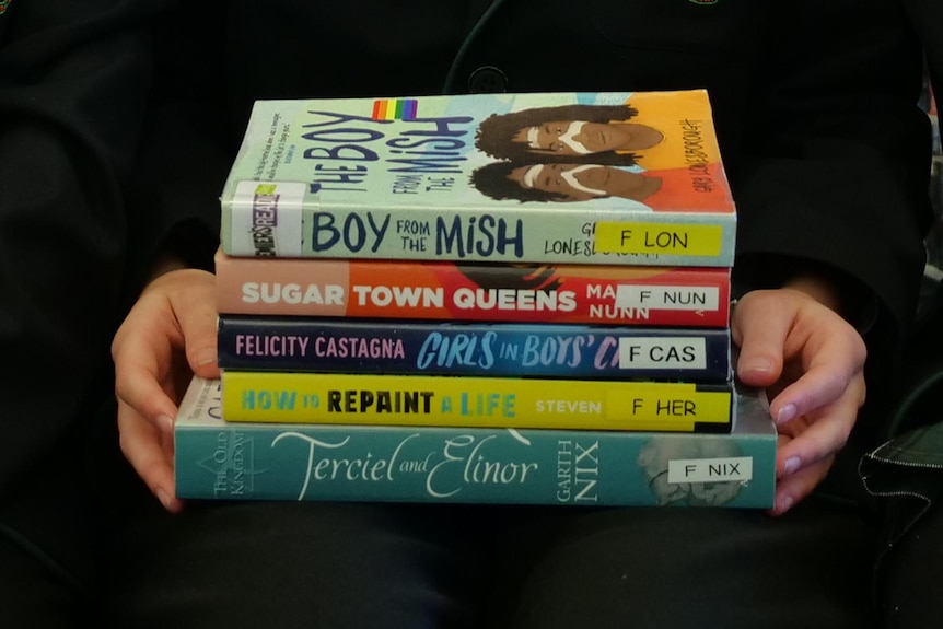 Three girls sitting with the shortlisted books.