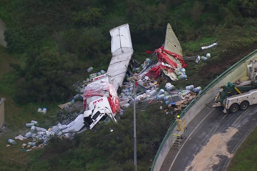 An aerial shot of a truck crashed along an embankment, significantly crumped on impact.