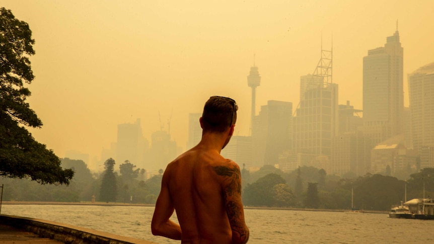 A man looks over a smoky Sydney skyline during the Black Summer bushfires