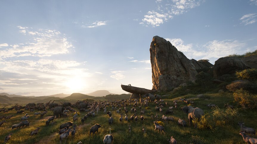 Colour still of animated animals gathering around elevated large rock face in African savanna in 2019 film The Lion King.