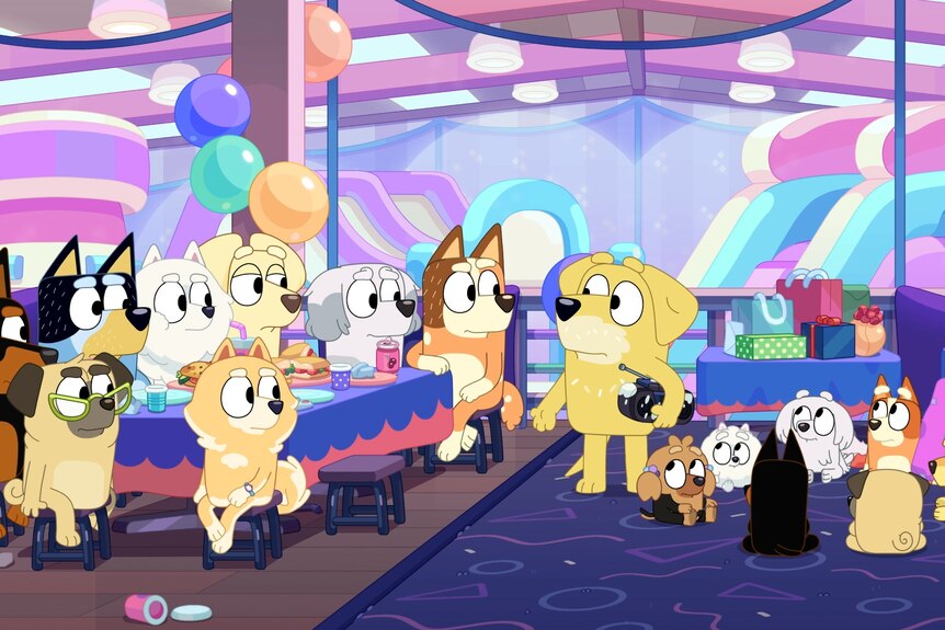 A cartoon dog holds a paint-covered radio at a pup's birthday party.