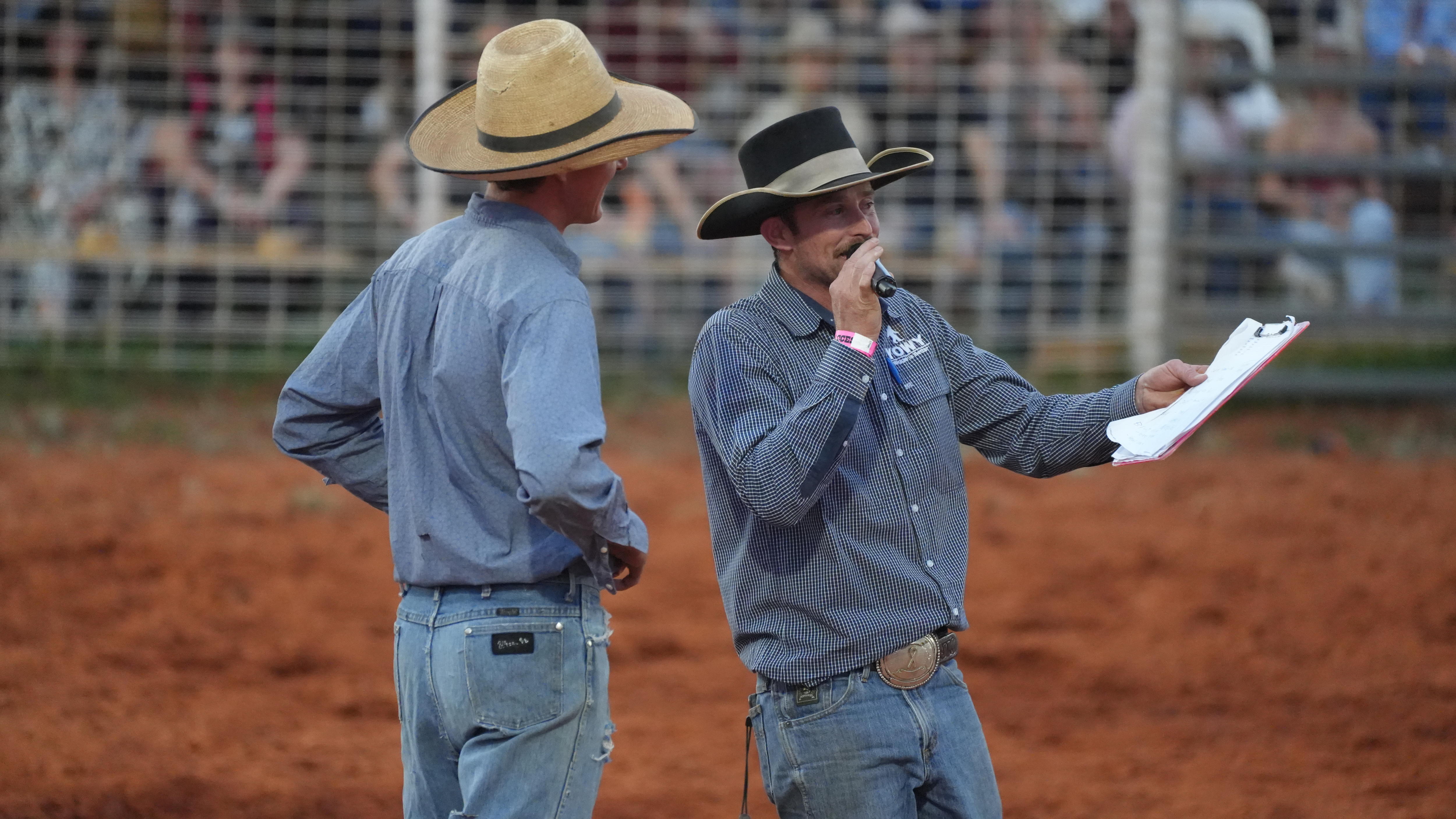 Two men in the arena, one with a microphone