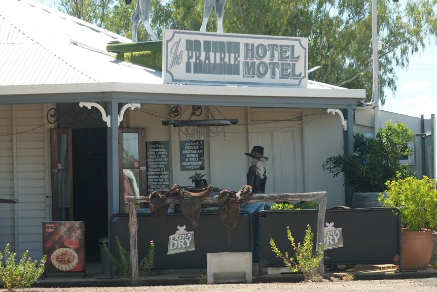 An Queenslander style outback pub with a sign which reads 'The Prairie Hotel Motel'