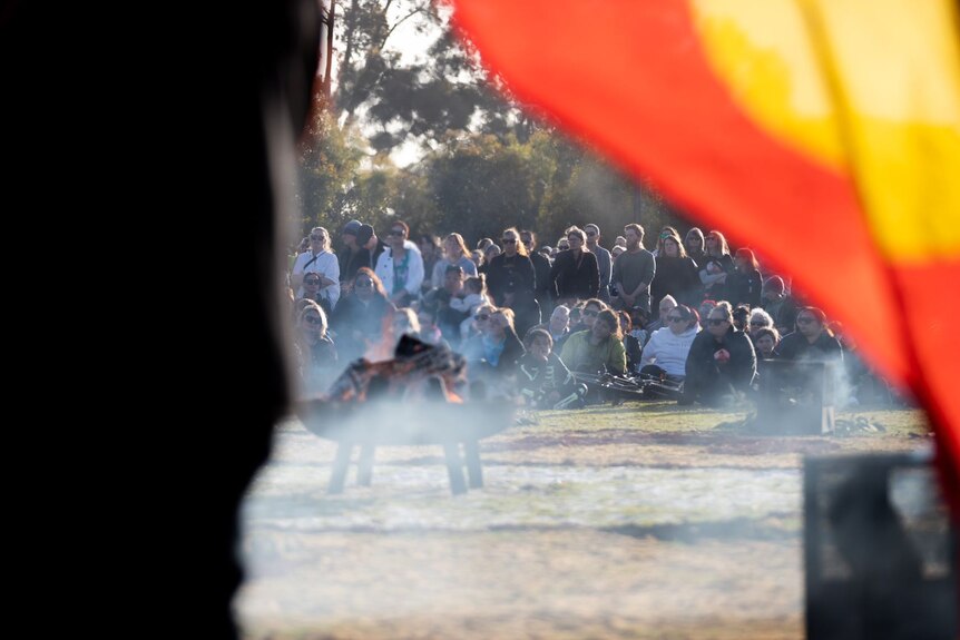 A smoking ceremony in front of a crowd