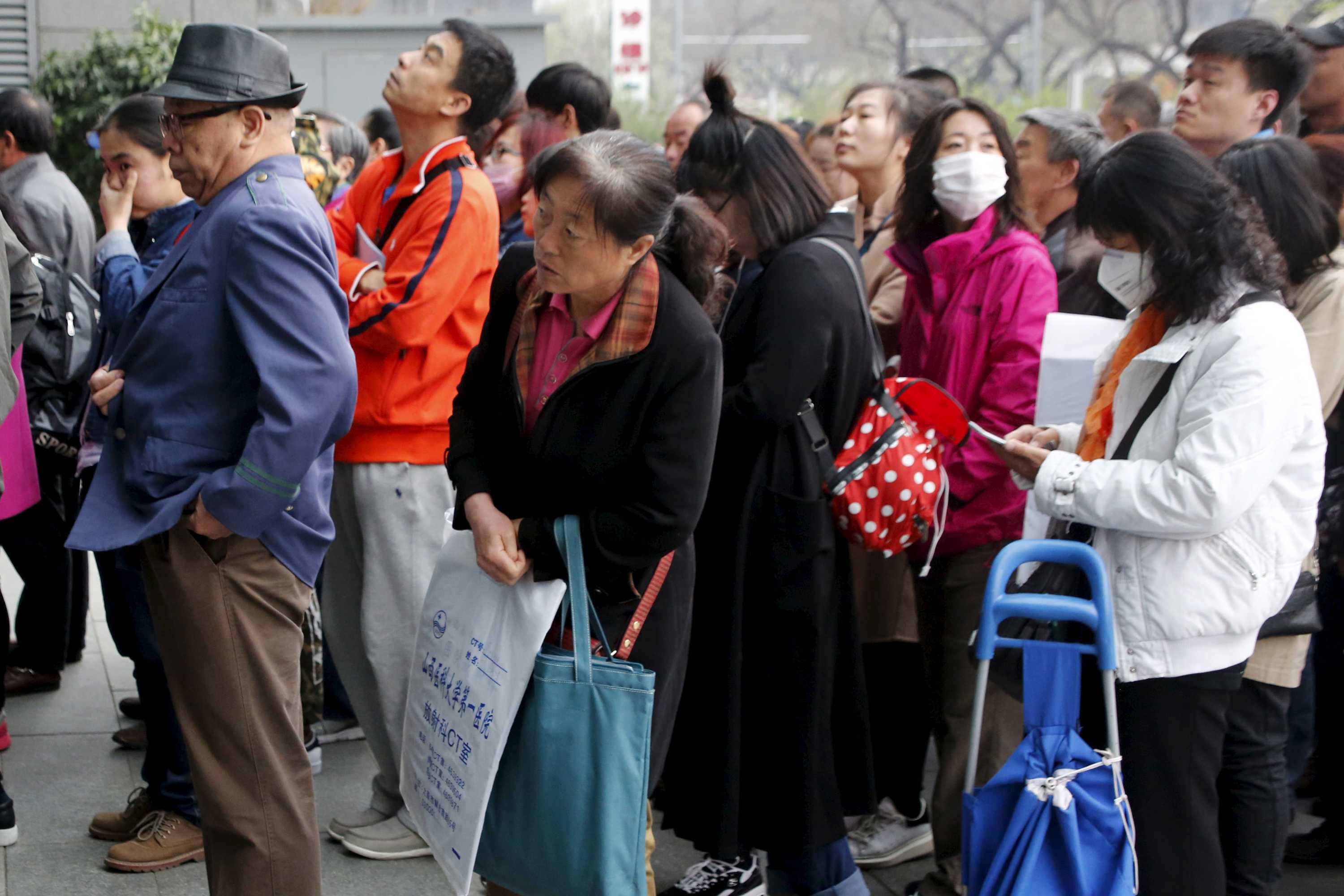 A crowd of Chinese people waiting to enter a hospital.
