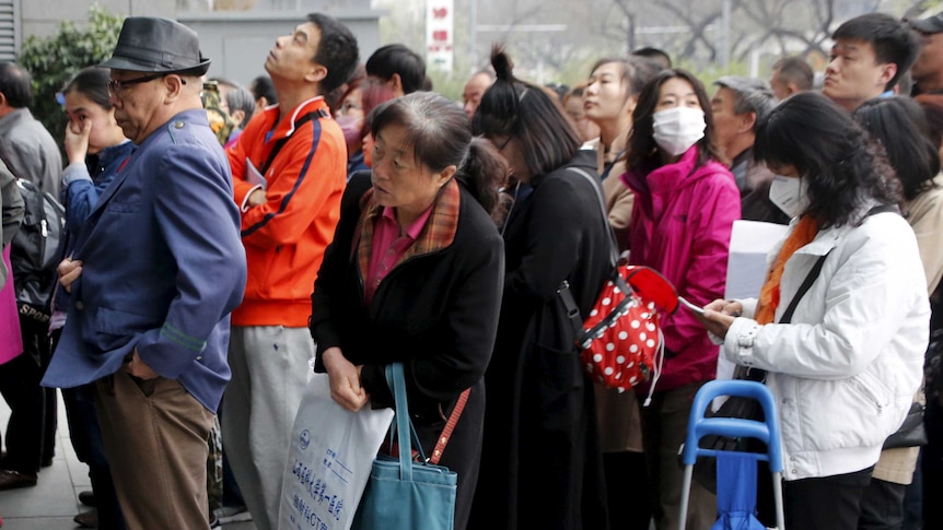 A crowd of Chinese people waiting to enter a hospital.