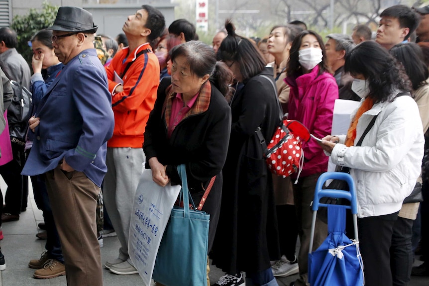 A crowd of Chinese people waiting to enter a hospital.