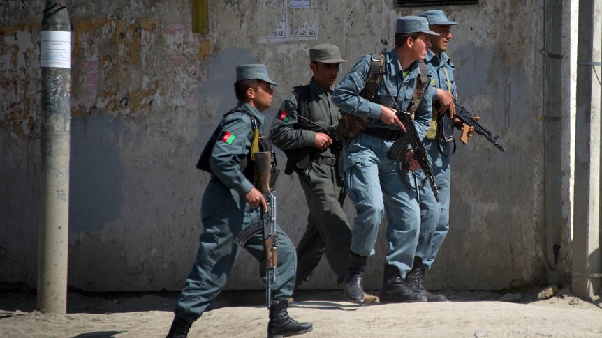 Coordinated terror ... Afghan police run towards the scene of attacks in Kabul.