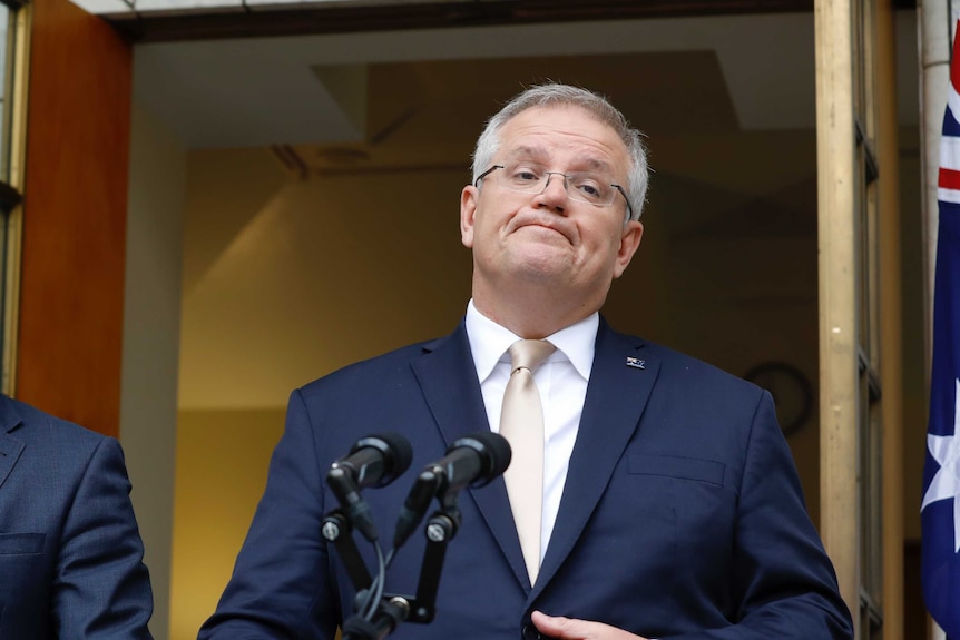 Scott Morrison sighs while standing in the PM's courtyard