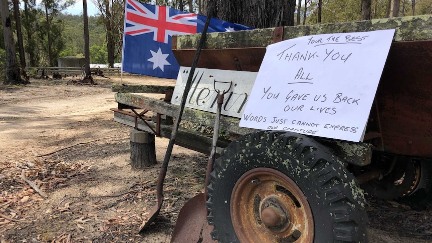 A handwritten note resting on an old trailer saying 'thank you' next to an Australian flag.