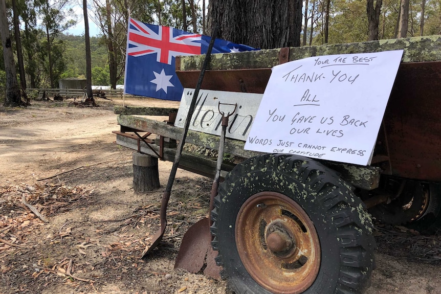 A handwritten note resting on an old trailer saying 'thank you' next to an Australian flag.